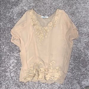 Sheet cream blouse with floral accent